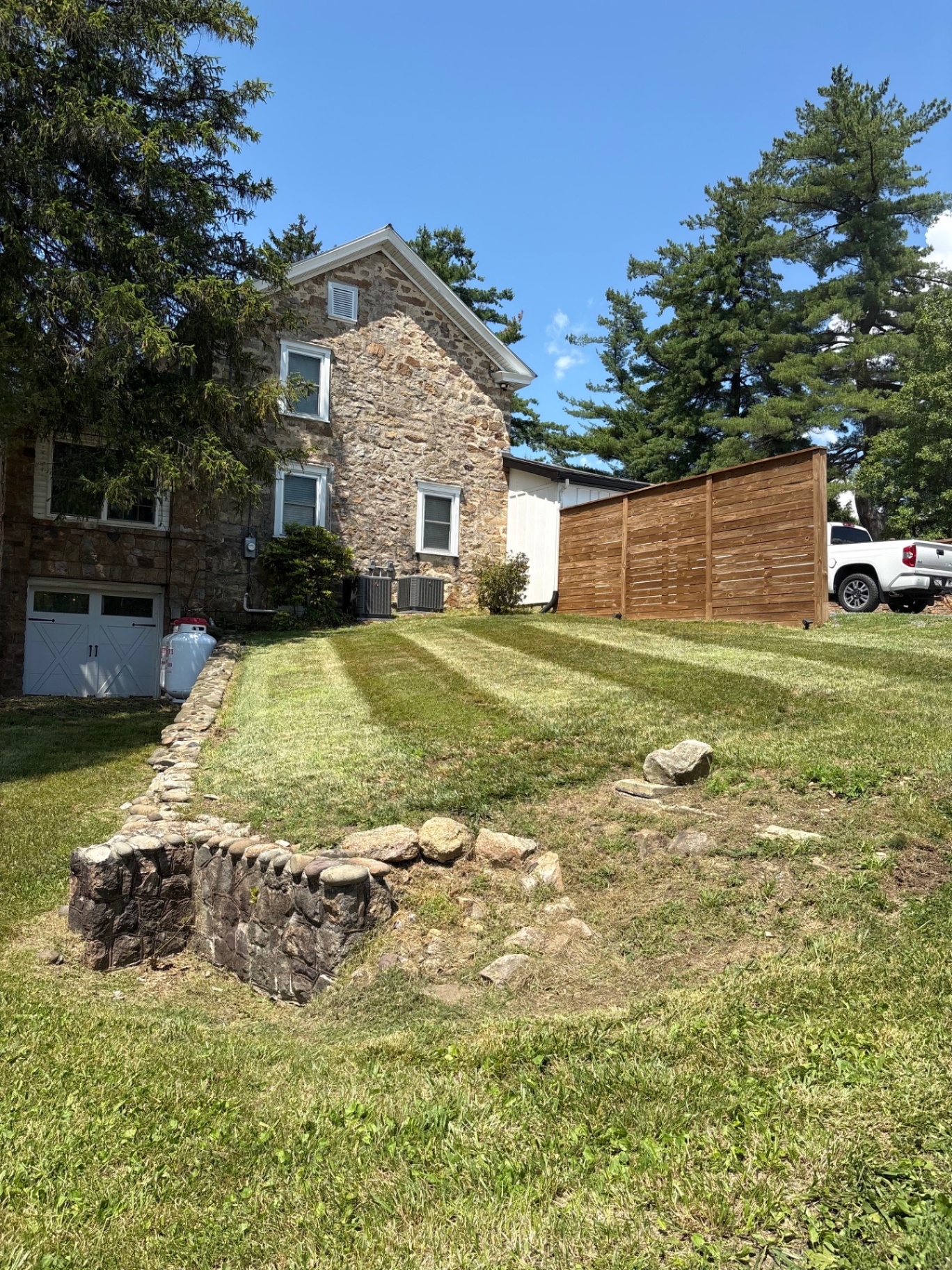 Stone farmhouse side lawn with fresh stripes